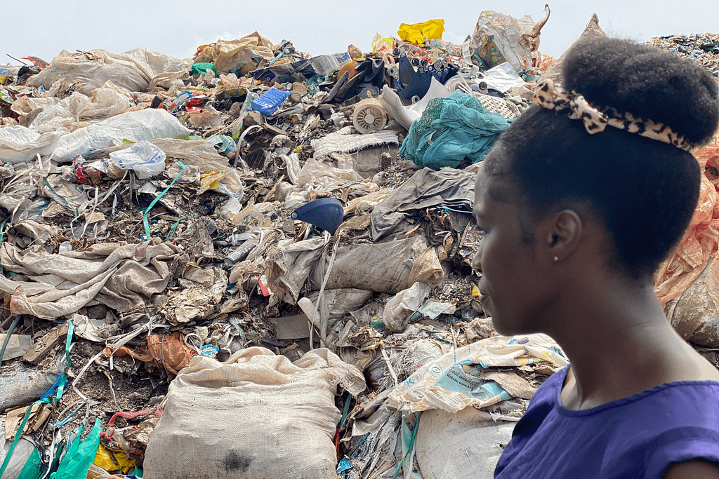lady standing next to trash