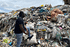 man standing next to a plastic landfill